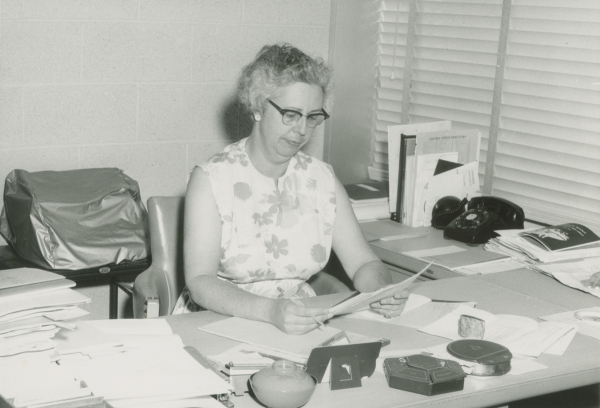Jean Lowrie sitting at a desk.